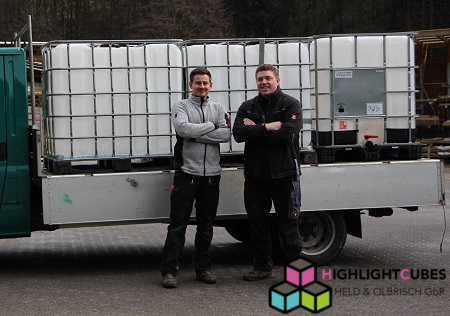 Zwei Personen vor LKW beladen mit drei IBC Wassertanks